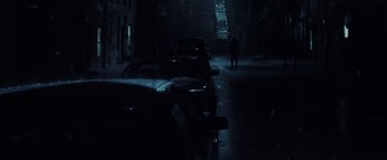 Movie still from “Unbreakable” (2000), directed by M. Night Shyamalan – A person walking down a street in the dark; Extreme Wide shot, Low angle