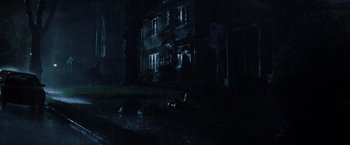 Movie still from “Unbreakable” (2000), directed by M. Night Shyamalan – A house that is dark with a cat laying in the grass; Extreme Wide shot, Low angle