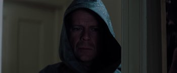 Movie still from “Unbreakable” (2000), directed by M. Night Shyamalan – A man wearing a hooded sweatshirt stares into the camera; Close Up shot, Low angle