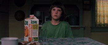 Movie still from “Unbreakable” (2000), directed by M. Night Shyamalan – A boy sitting at a table in front of a glass of milk; Close Up shot, Over the shoulder angle