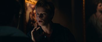 Movie still from “Uncharted” (2022), directed by Ruben Fleischer – A man with blonde hair is looking into the dark; Close Up shot, Over the shoulder angle