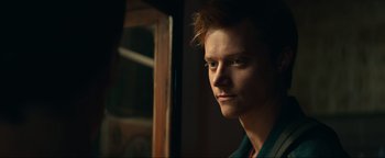 Movie still from “Uncharted” (2022), directed by Ruben Fleischer – A young man looking out of a window; Close Up shot, Over the shoulder angle