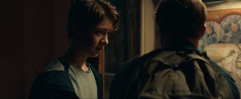 Movie still from “Uncharted” (2022), directed by Ruben Fleischer – A young man standing next to another young man; Close Up shot, Over the shoulder angle