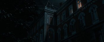 Movie still from “Uncharted” (2022), directed by Ruben Fleischer – A building that is lit up at night time; Extreme Wide shot, Low angle