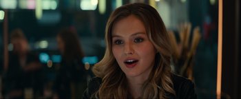 Movie still from “Uncharted” (2022), directed by Ruben Fleischer – A beautiful young woman with long , blonde hair; Close Up shot, Over the shoulder angle