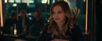 Movie still from “Uncharted” (2022), directed by Ruben Fleischer – A beautiful young lady sitting at a table in a restaurant; Close Up shot, Over the shoulder angle