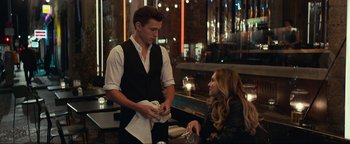 Movie still from “Uncharted” (2022), directed by Ruben Fleischer – A man and a woman are talking in front of a table; Medium shot, Over the shoulder angle
