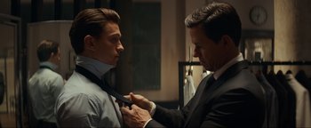 Movie still from “Uncharted” (2022), directed by Ruben Fleischer – A man helping another man fix his tie; Medium shot, Over the shoulder angle