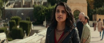 Movie still from “Uncharted” (2022), directed by Ruben Fleischer – A woman in a black jacket standing in front of a building; Close Up shot, Over the shoulder angle