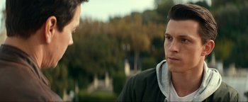 Movie still from “Uncharted” (2022), directed by Ruben Fleischer – Two young men talking to each other in a park; Close Up shot, Over the shoulder angle