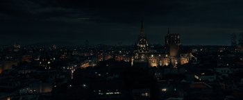Movie still from “Uncharted” (2022), directed by Ruben Fleischer – A dark city skyline at night with lights on; Extreme Wide shot, High angle