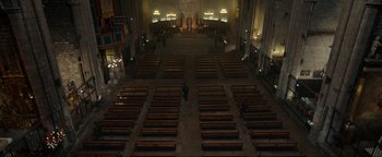 Movie still from “Uncharted” (2022), directed by Ruben Fleischer – A man standing in the middle of an empty church; Extreme Wide shot, High angle