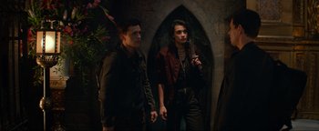 Movie still from “Uncharted” (2022), directed by Ruben Fleischer – Two young men standing next to each other in front of an archway; Medium shot, Over the shoulder angle