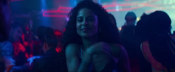 Movie still from “Uncharted” (2022), directed by Ruben Fleischer – A beautiful young lady posing for a picture in a nightclub; Close Up shot, Low angle