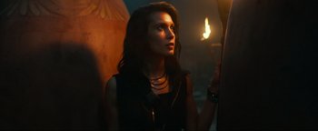 Movie still from “Uncharted” (2022), directed by Ruben Fleischer – A beautiful woman holding a lit candle in a dark room; Close Up shot, Low angle