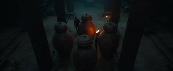 Movie still from “Uncharted” (2022), directed by Ruben Fleischer – A group of large vases are lit by a candle; Extreme Wide shot, High angle