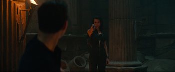 Movie still from “Uncharted” (2022), directed by Ruben Fleischer – A woman holding a gun in front of a mirror; Medium shot, Over the shoulder angle