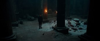 Movie still from “Uncharted” (2022), directed by Ruben Fleischer – A man standing next to a pillar in the middle of the night; Extreme Wide shot, High angle