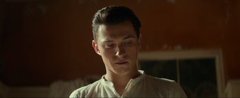 Movie still from “Uncharted” (2022), directed by Ruben Fleischer – A young man is looking down at his face; Close Up shot, Low angle