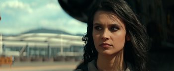 Movie still from “Uncharted” (2022), directed by Ruben Fleischer – A person with long black hair; Close Up shot, Low angle