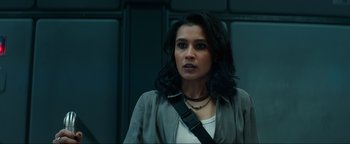 Movie still from “Uncharted” (2022), directed by Ruben Fleischer – A woman with long black hair wearing a white shirt; Close Up shot, Low angle