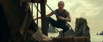 Movie still from “Uncharted” (2022), directed by Ruben Fleischer – A woman with a tattoo is climbing on a boat; Medium shot, Low angle