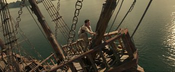 Movie still from “Uncharted” (2022), directed by Ruben Fleischer – A man standing on top of a wooden structure; Wide shot, Low angle
