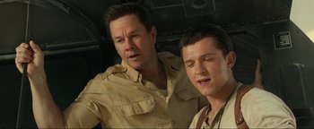 Movie still from “Uncharted” (2022), directed by Ruben Fleischer – A man and a boy standing next to each other; Close Up shot, Low angle