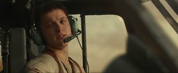 Movie still from “Uncharted” (2022), directed by Ruben Fleischer – A man in a helicopter with a headset on; Close Up shot, Over the shoulder angle