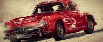 Movie still from “Uncharted” (2022), directed by Ruben Fleischer – A red car is driving down the street; Wide shot, High angle