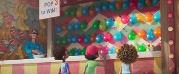 Movie still from “Under the Boardwalk” (2023), directed by David Soren – A group of people standing in front of a wall of balloons; Medium shot, Over the shoulder angle