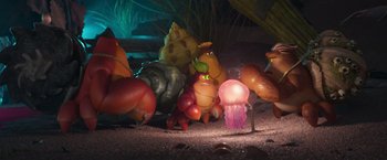 Movie still from “Under the Boardwalk” (2023), directed by David Soren – A group of plastic animals sitting on top of a sandy beach; Wide shot, High angle