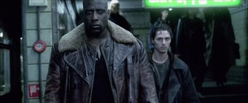 Movie still from “Underworld” (2003), directed by Len Wiseman – A man in a leather jacket standing next to another man in a leather jacket; Medium shot, Low angle