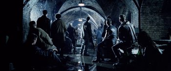 Movie still from “Underworld” (2003), directed by Len Wiseman – A group of people standing around in a room; Wide shot, High angle