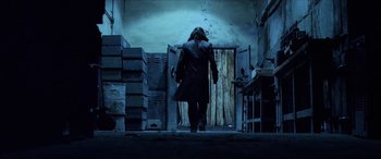 Movie still from “Underworld” (2003), directed by Len Wiseman – A man walking down the stairs in a dark room; Wide shot, Low angle