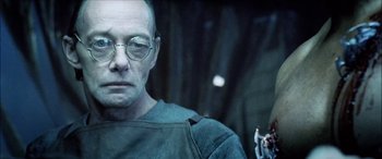 Movie still from “Underworld” (2003), directed by Len Wiseman – A man with glasses is looking at the camera; Close Up shot, Over the shoulder angle