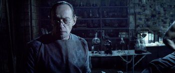 Movie still from “Underworld” (2003), directed by Len Wiseman – An older man in a lab with a lot of lab glassware; Medium shot, Low angle