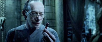 Movie still from “Underworld” (2003), directed by Len Wiseman – An old man holding a glass bottle in his hand; Close Up shot, High angle