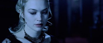 Movie still from “Underworld” (2003), directed by Len Wiseman – A beautiful woman with long blonde hair wearing a necklace; Close Up shot, Over the shoulder angle