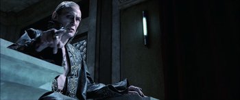 Movie still from “Underworld” (2003), directed by Len Wiseman – A man in a black suit and a light in a room; Close Up shot, Over the shoulder angle