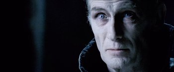 Movie still from “Underworld” (2003), directed by Len Wiseman – An old man with a white beard and blue eyes looking at the camera; Close Up shot, Over the shoulder angle