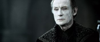 Movie still from “Underworld” (2003), directed by Len Wiseman – An older man with a white beard and a black shirt; Close Up shot, High angle