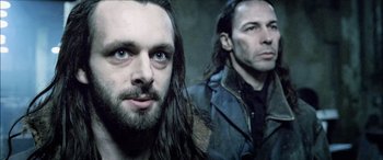 Movie still from “Underworld” (2003), directed by Len Wiseman – A man with long hair and a man with long hair; Close Up shot, Low angle