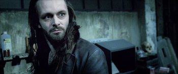 Movie still from “Underworld” (2003), directed by Len Wiseman – A man with long hair and beard wearing a leather jacket; Close Up shot, Low angle