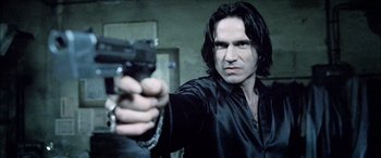 Movie still from “Underworld” (2003), directed by Len Wiseman – A man holding a gun in a room; Close Up shot, Low angle