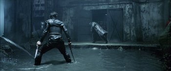 Movie still from “Underworld” (2003), directed by Len Wiseman – Two people in a flooded area with a knife in their hand; Wide shot, Over the shoulder angle