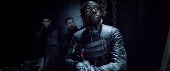 Movie still from “Underworld” (2003), directed by Len Wiseman – A man holding a gun while standing next to another man; Medium shot, Low angle