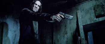 Movie still from “Underworld” (2003), directed by Len Wiseman – A man holding a gun in a dark room; Medium shot, Low angle