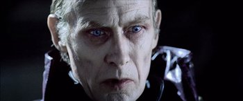 Movie still from “Underworld” (2003), directed by Len Wiseman – An older man with blue eyes stares into the camera; Close Up shot, Over the shoulder angle