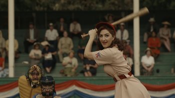 Movie still from “A League of Their Own” (2022), created by Abbi Jacobson – A woman in a baseball uniform holding a baseball bat; Medium shot, Over the shoulder angle